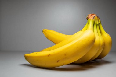 Gri arka planda bir sürü sarı muz. Yumuşak odak.