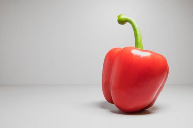 Beyaz arka planda uzun, yeşil saplı kırmızı dolma biber..