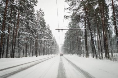 Arabanın ön camından bak. Kışın karlı bir yolda araba sürmek.