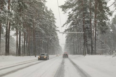 Arabanın ön camından bak. Araba kışın kaygan, karlı bir yolda gidiyor..