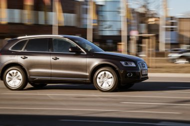 Audi Q5 sokağın aşağısına gidiyor. Şehirde hızlı giden bir araba. Riga, Letonya - 16 Mar 2022