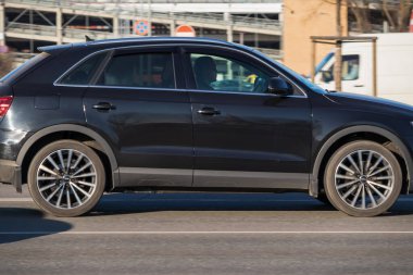 Caddede küçük siyah SUV 'ler var. Yan görüntüyü yakından çek. Audi Q3. Riga, Letonya - 15 Mar 2022.