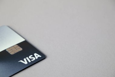Gri arka planda VISA banka kartı ve mesaj için boş yer var. Riga, Letonya - 26 Mar 2022.