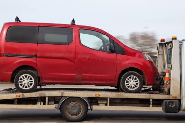 Kırmızı yolcu minibüsü çekici ile taşınır. Araba tahliyesi, transfer, araba servisine teslimat. Hareket bulanıklığı.