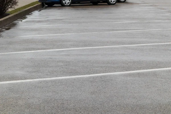 Araba parkı. Yağmurda beyaz çizgileri olan yakın otoparklar. Yumuşak odak.
