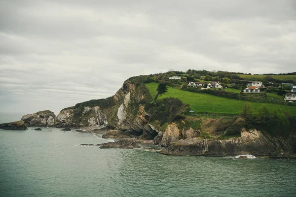 Okyanus kıyısındaki tepedeki villalar. Kayalık bir deniz kıyısında yaşıyor