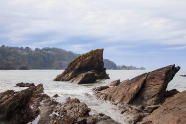 Okyanustaki büyük kaya, bulutlu gökyüzü. Okyanustaki uçurum.
