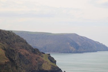 Büyük dağlar, okyanus kıyısındaki kayalıklar. Kaya kıyısı, bulutlu hava.