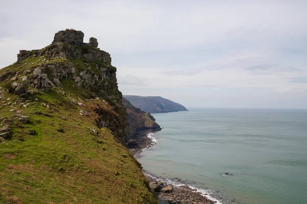 Büyük dağlar, okyanus kıyısındaki kayalıklar. Bulutlu havada dumanlı okyanus. Lynmouth, Devon, İngiltere, İngiltere.
