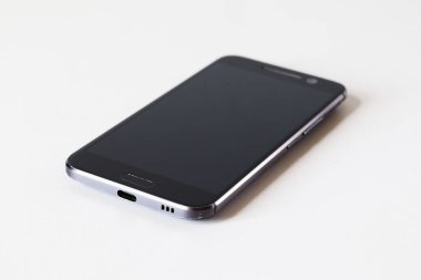 Beyaz masadaki akıllı telefon, yakın plan. Seçici odak