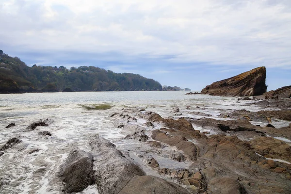 Fırtınadan önce bulutlu havada kayalıkları olan okyanus kıyısı..