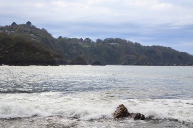 Fırtınadan önce bulutlu havada kayalıkları olan okyanus kıyısı..