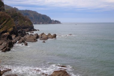 Fırtınadan önce bulutlu havada kayalıkları ve kayalıkları olan deniz kıyısı.