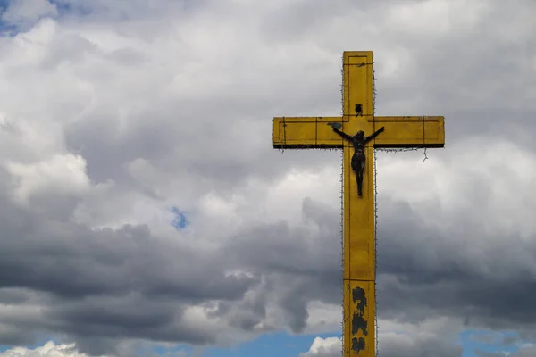 A large cross on a background of clouds with free space for text.