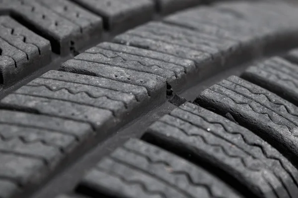 Tire tread background. Abstract texture of black car tire tread pattern close-up. Soft focus.