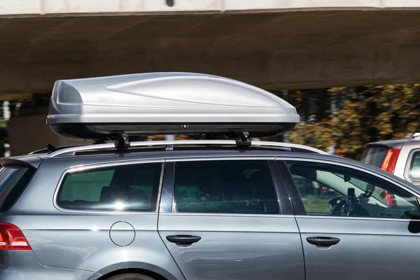 A car with a roof box. The roof rack is attached to the roof of the car.