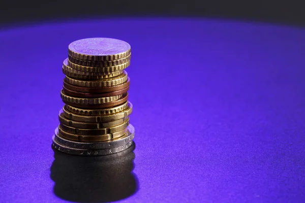 Stack of coins. Euro coins in a pile illuminated with blue light and with free space for text, copy space.