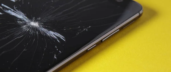 Banner with a broken phone screen close-up on a yellow background. Torn, cracked smartphone screen.