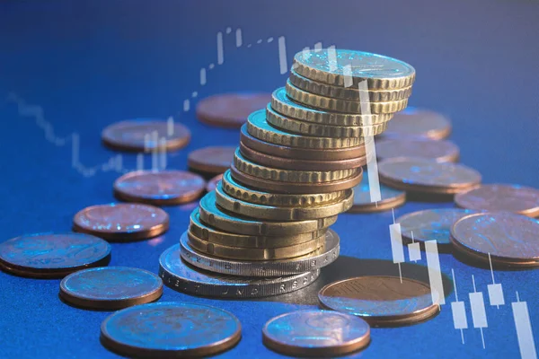 Stack of euro coins and market chart graph with downward trend, loss of value. Soft focus