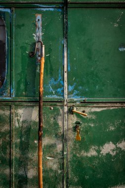 Kilitli paslı metal bir kapı.