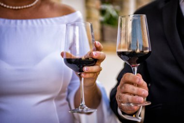 Şarap kadehleri ve bir bardak şampanyayla kadeh kaldıran çiftler.