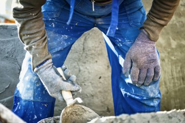 Kil miğferli bir inşaat işçisi ve bina zemininde çalışıyor..