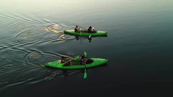 Волынь, Украина - 08 августа 2021 года: Два зеленых каяка с молодыми украинскими мужчинами и женщинами, плавающими по чистой воде. — стоковое видео
