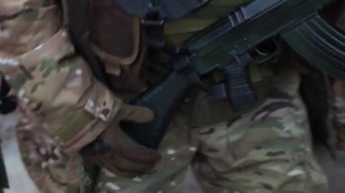 Ukraynalı bir askerin elinde yeşil makineli tüfek. Gitar çalarken parmaklar taklit eder.