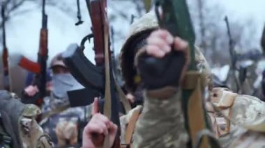 Kyiv, Ukrayna - 31 Mart 2022: Sağ ellerinde makineli tüfeklerle Ukrayna askerleri. Silahlarını sallar ve vücutlarını hareket ettirirler..