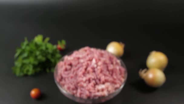 Vertical panorama from a dark background on a glass bowl filled with minced veal, chicken and pork. — Video Stock