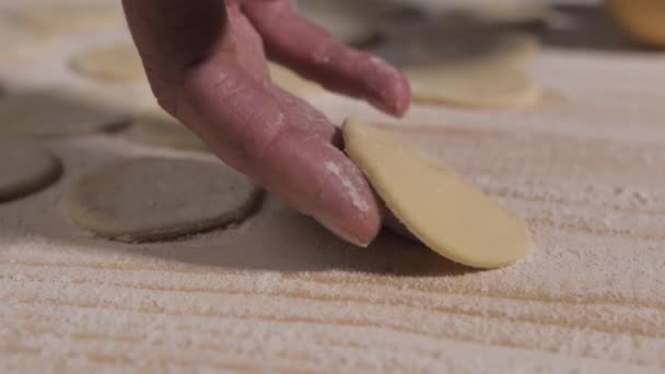 为饺子做的木制表面面团上的女性脆弱的手指，有修指甲. — 图库视频影像