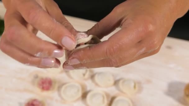 Knoedels maken. Chef-kok handen vormen kleine handgemaakte ravioli op keukentafel. — Stockvideo