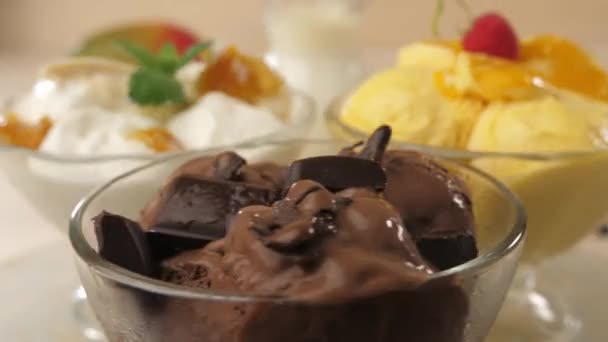 Skleněné misky naplněné zmrzlinou se zmrzlinou, čokoládou, mangem a banánem. — Stock video