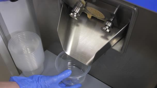 Arbetstagarens hand ersätter en plastbehållare för att fylla glass. — Stockvideo