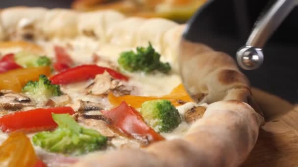 Sebuah pisau pizza berguling di atas permukaan pizza segar, memotongnya. — Stok Video