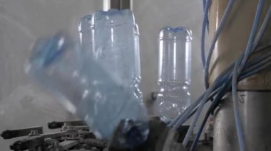 Plastik şişeleri tıkırdatmadan önce durulama işlemi. Yiyecek işleme tesisinde içme suyu üretimi.