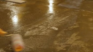 Astarın beton zemine rulo ile uygulanması. Sıvalı bir yüzeyi hazırlama süreci. Beton zemin astar yüzeyi güçlendirmek için.