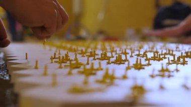 Seramik fayanslar yerleştiriliyor. Parçaları ölçüyor ve kesiyor. İşçi seramik fayanslar arasına plastik haçlar yerleştirir.