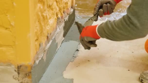 Ręce Pracownika Czerwonych Rękawiczkach Używają Szpatułki Wyłożenia Żółtej Ściany Podłogą — Wideo stockowe