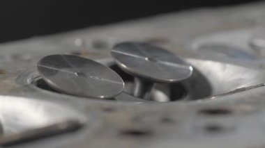 Valves in the cylinder head. Clean - after cleaning the car parts. The light shines on a shiny surface.