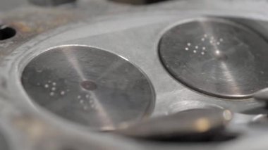 Old cylinder head block with valves. Close-up. Clean details. The movement of the camera on the slider is parallel to the details.