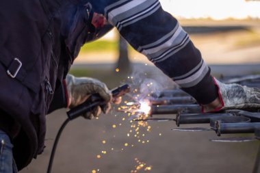 Kaynak makinesi, kaynakçı miğferi takarak ızgaraya kaynak yapıyor. Çok güzel bir kaynak flaşla.