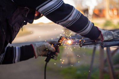 Kaynakçı, kaynakçı kaskıyla ızgarayı kaynaklıyor.