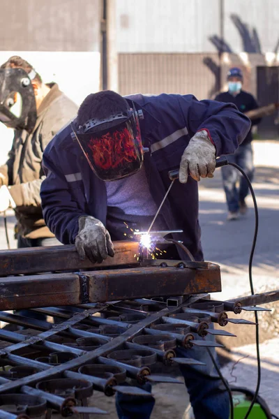 Kaynak yapan bir kaynakçı, kaynakçı kaskı takıyor ve çok güzel bir kaynak yapıyor.