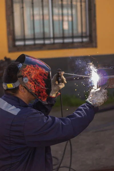 Kaynak yapan bir kaynakçı, kaynakçı kaskı takıyor ve çok güzel bir kaynak yapıyor.