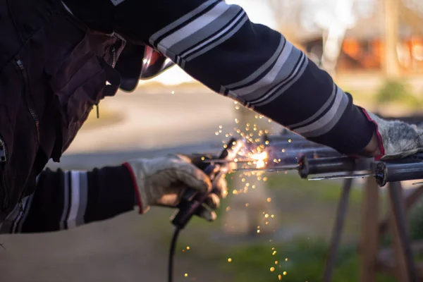 Kaynak makinesi, kaynakçı miğferi takarak ızgaraya kaynak yapıyor. Çok güzel bir kaynak flaşla.