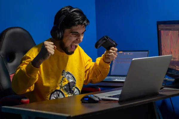 Adam evde video oyunu oynayarak zaferini kutluyor. Oyuncu ve flamalı.