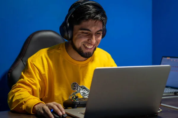 Adam evde video oyunu oynarken odaklanmış. Oyuncu ve Teknoloji.