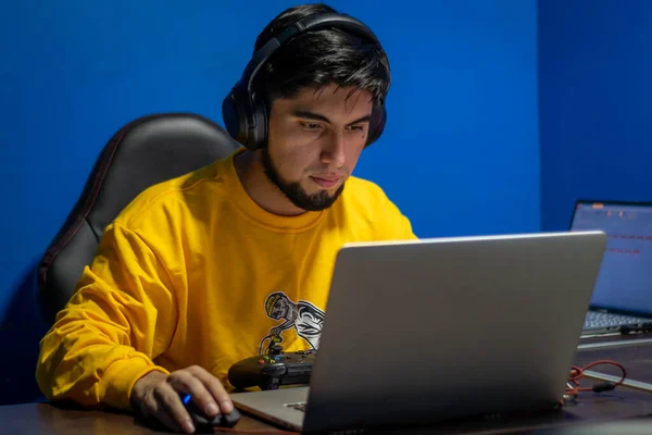 Adam evde video oyunu oynarken odaklanmış. Oyuncu ve Teknoloji.