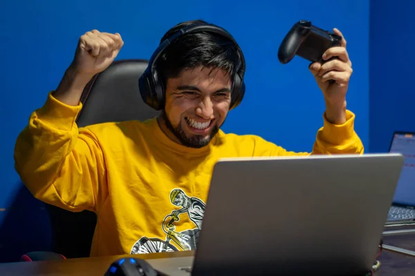 Adam evde video oyunu oynayarak zaferini kutluyor. Oyuncu ve flamalı.